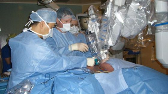Dr. Kazuhiro Yasufuku, Director of the Interventional Thoracic Surgical Program at Toronto General Hospital, University Health Network; Dr. Tom Waddell, thoracic surgeon and Head of the Division of Thoracic Surgery and thoracic surgical fellow Dr. Mauricio Pipkin carefully attach the first of the four robotic arms on to one of the steel ports in the patient’s chest. The robotic arms are docked on to the four ports through which surgical instruments and camera are maneuvered by the surgeon sitting in a console with a monitor and hand controls several feet away from the patient.